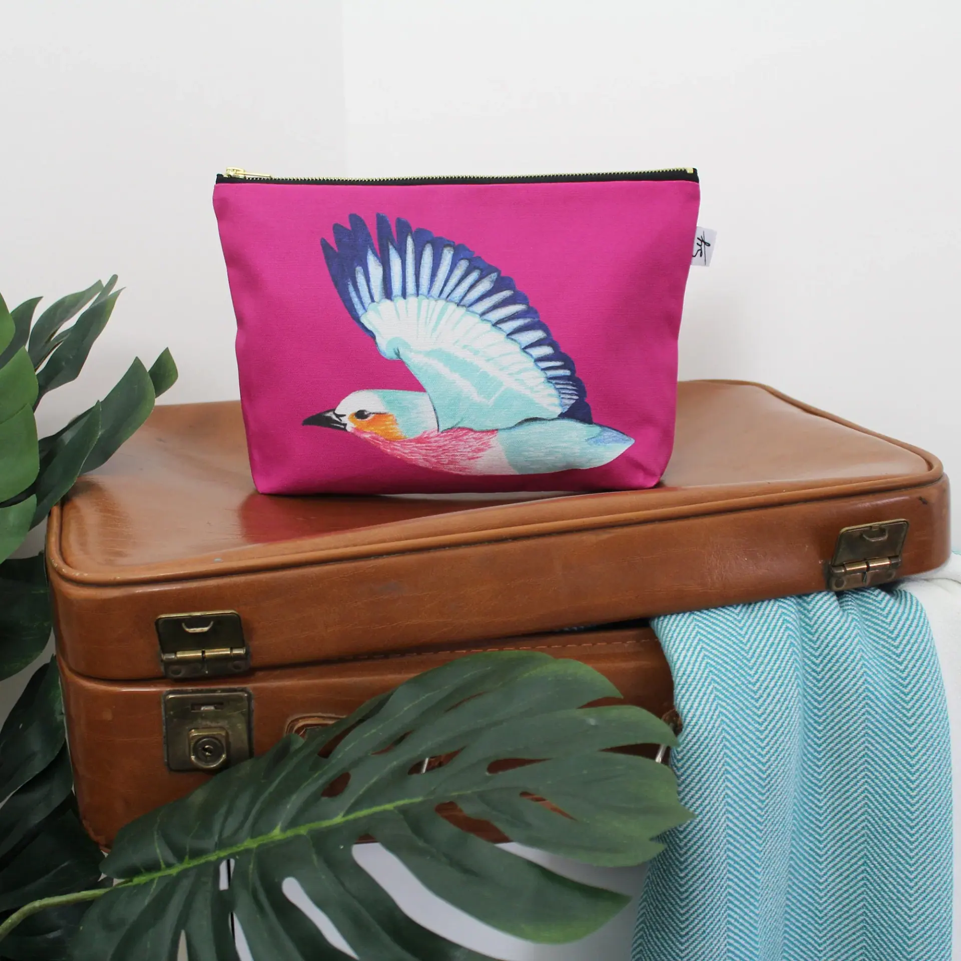 Safari Bird wash bag: a lilac-breasted roller in flight on cherry pink cotton with a gold zip