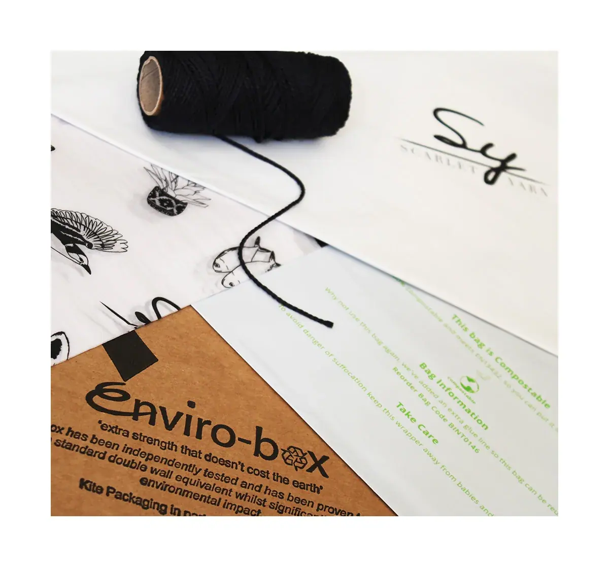 A recyclable Enviro-box and compostable mailing bag with Scarlet Yarn tissue and black twine